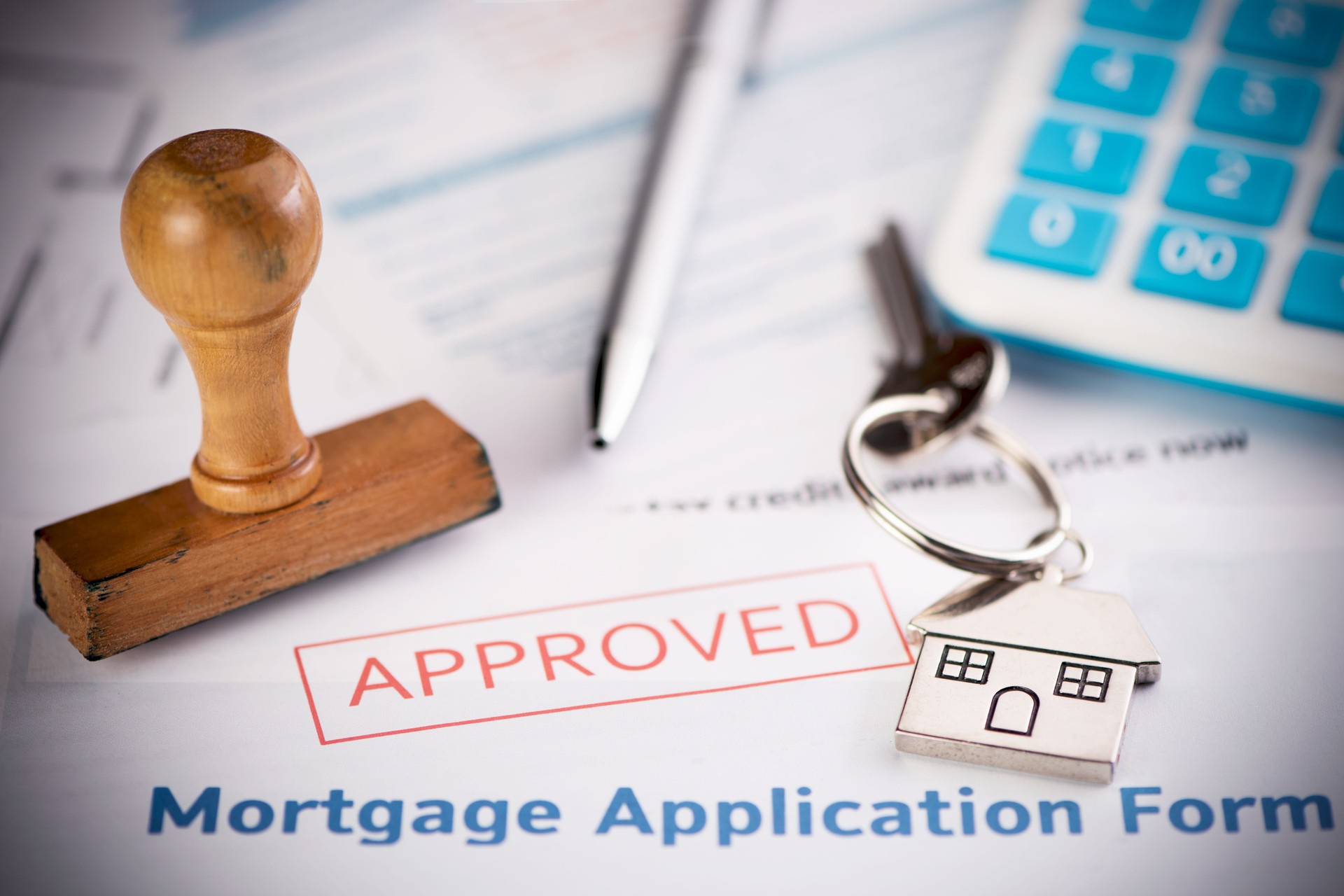 An approved Mortgage loan application form with house key and rubber stamp